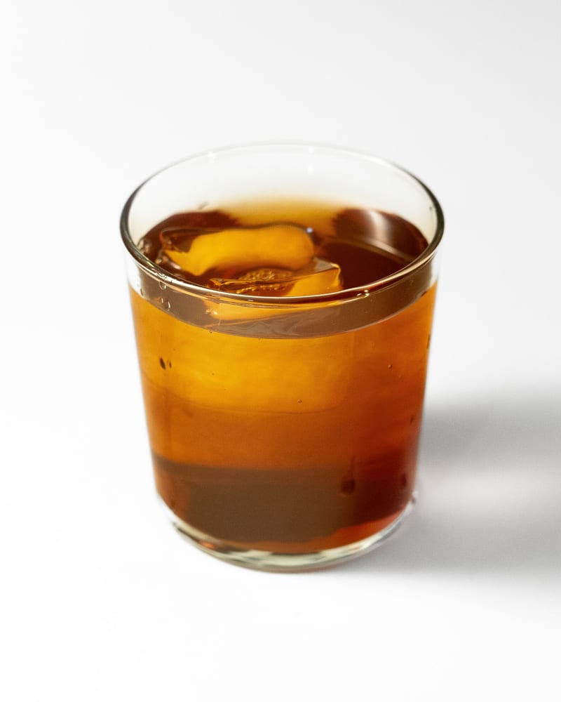 Cold brew poured into a short glass over a single large ice cube.